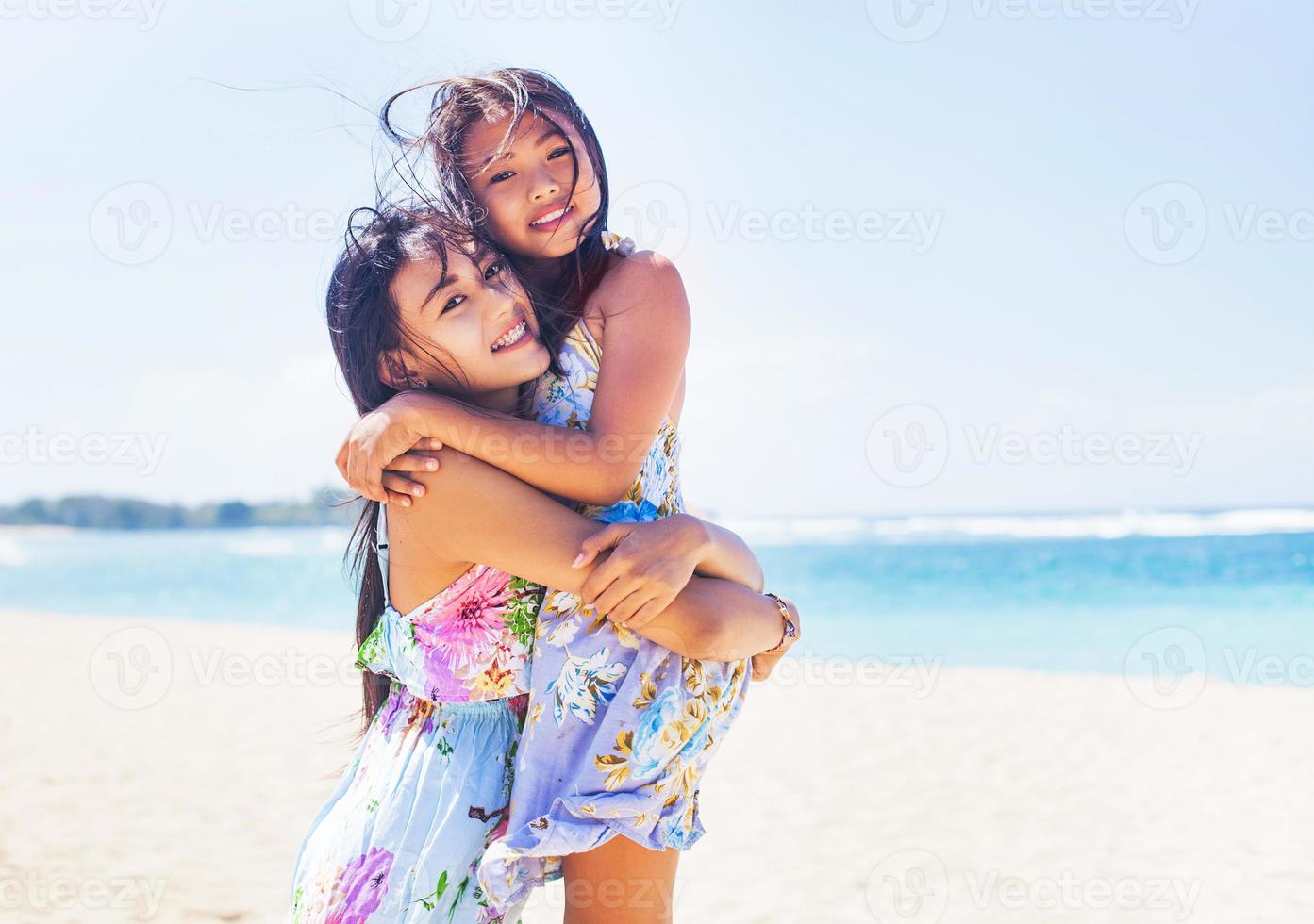 zwei asiatische Schwestern am Strand foto