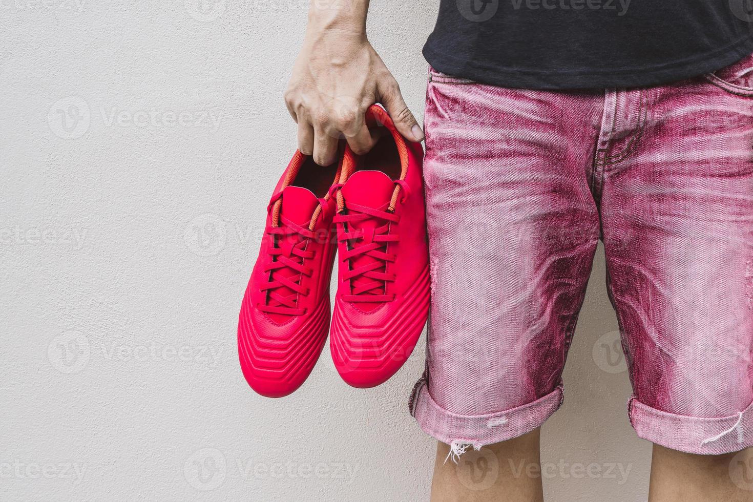 Mann, der Fußballschuhe in der Hand hält. foto