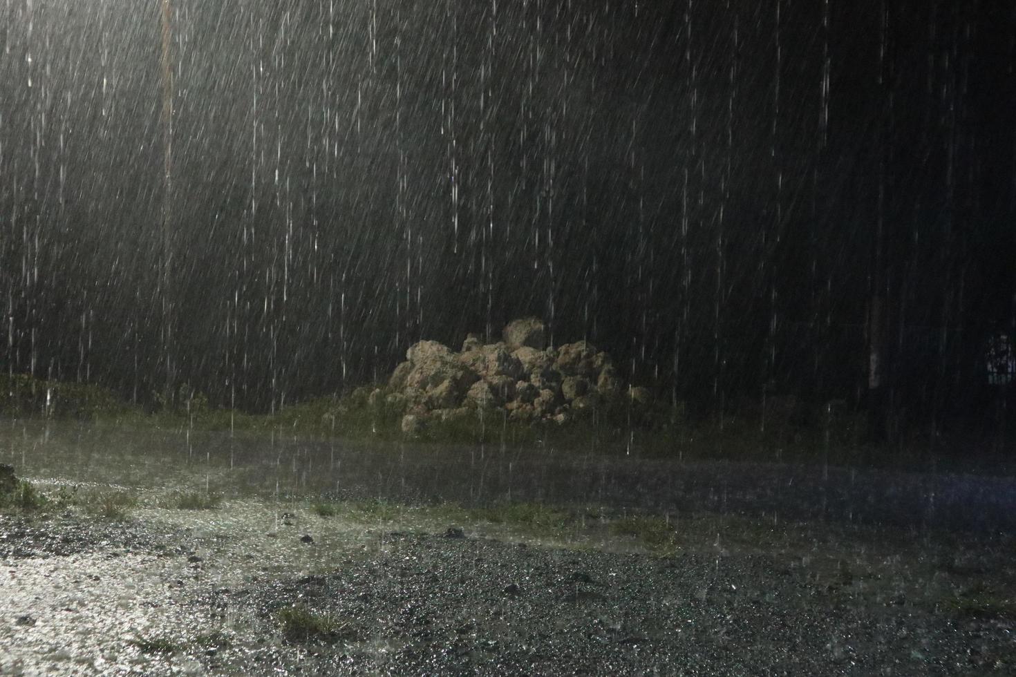 Regen in der Nacht. dunkle Hintergrundaufnahme von fallendem Regen foto