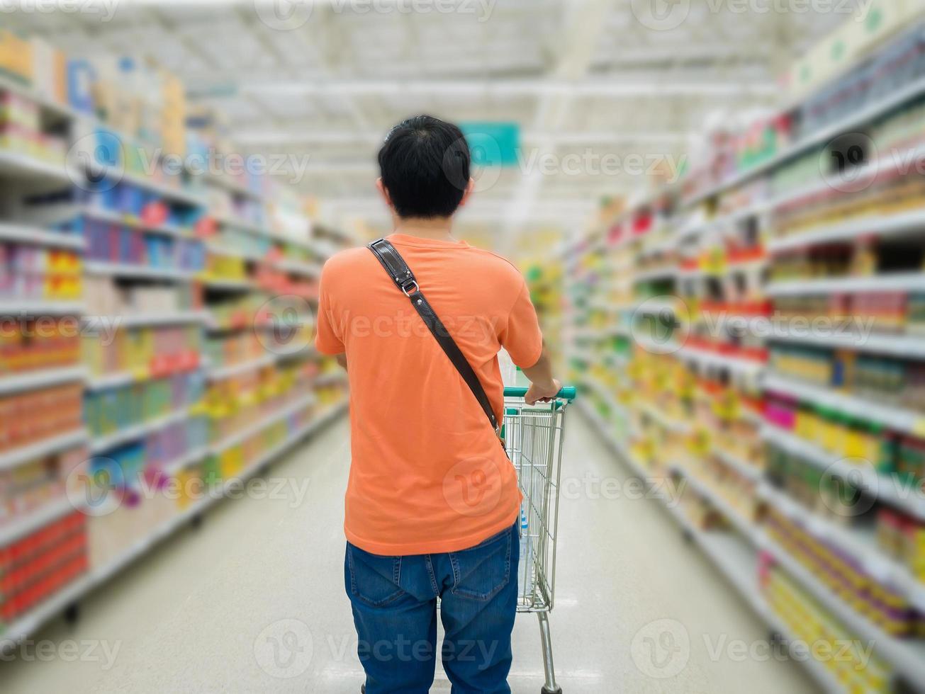 junger Mann, der im Supermarkt einkauft foto
