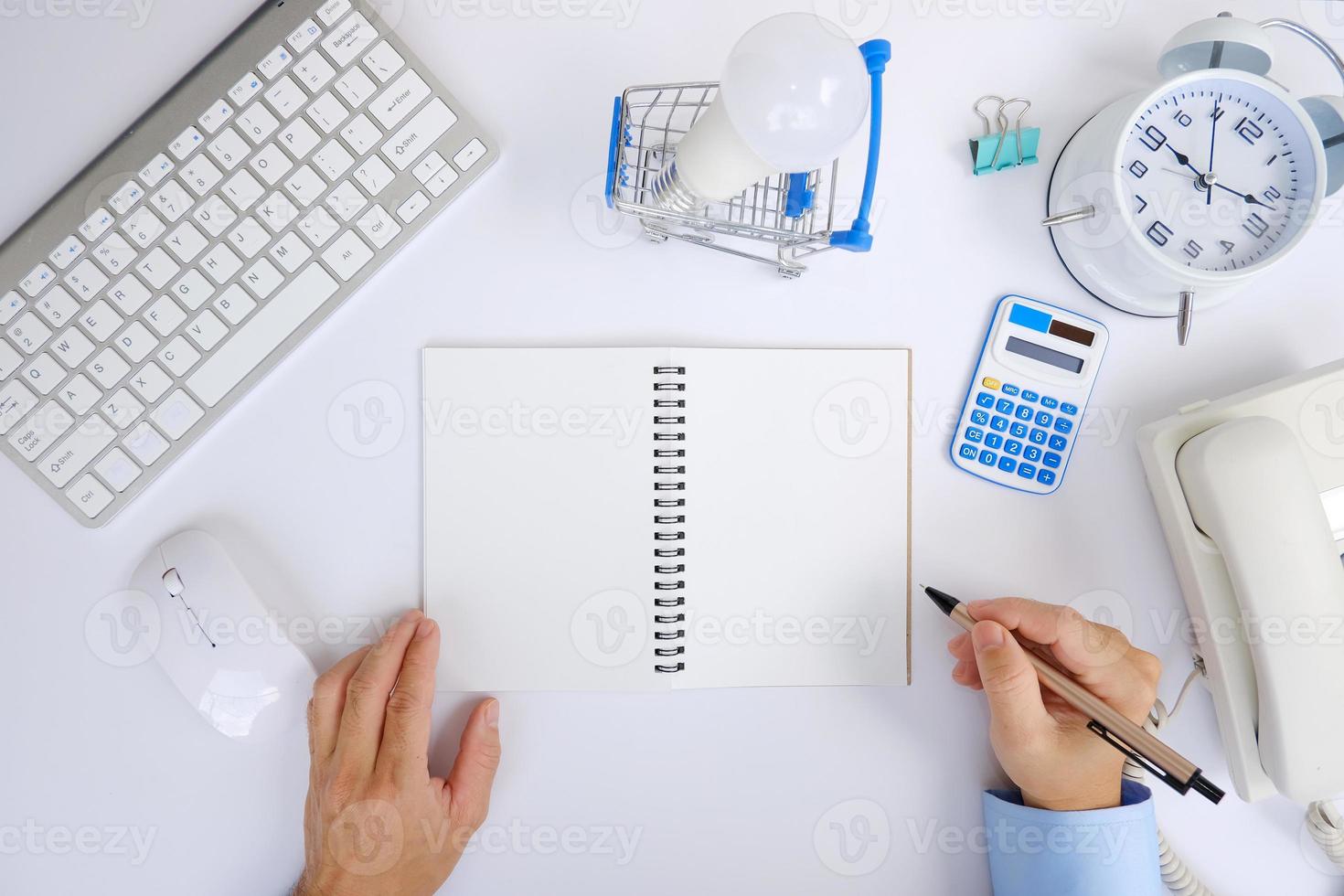 bürotisch mit smartphone, laptop, tasse kaffee und bürowerkzeugen. flache Lage, Draufsicht mit Kopierbereich. ein geldscheinblock und ein stift befinden sich auf einem bürotisch mit computerwerkzeugen foto