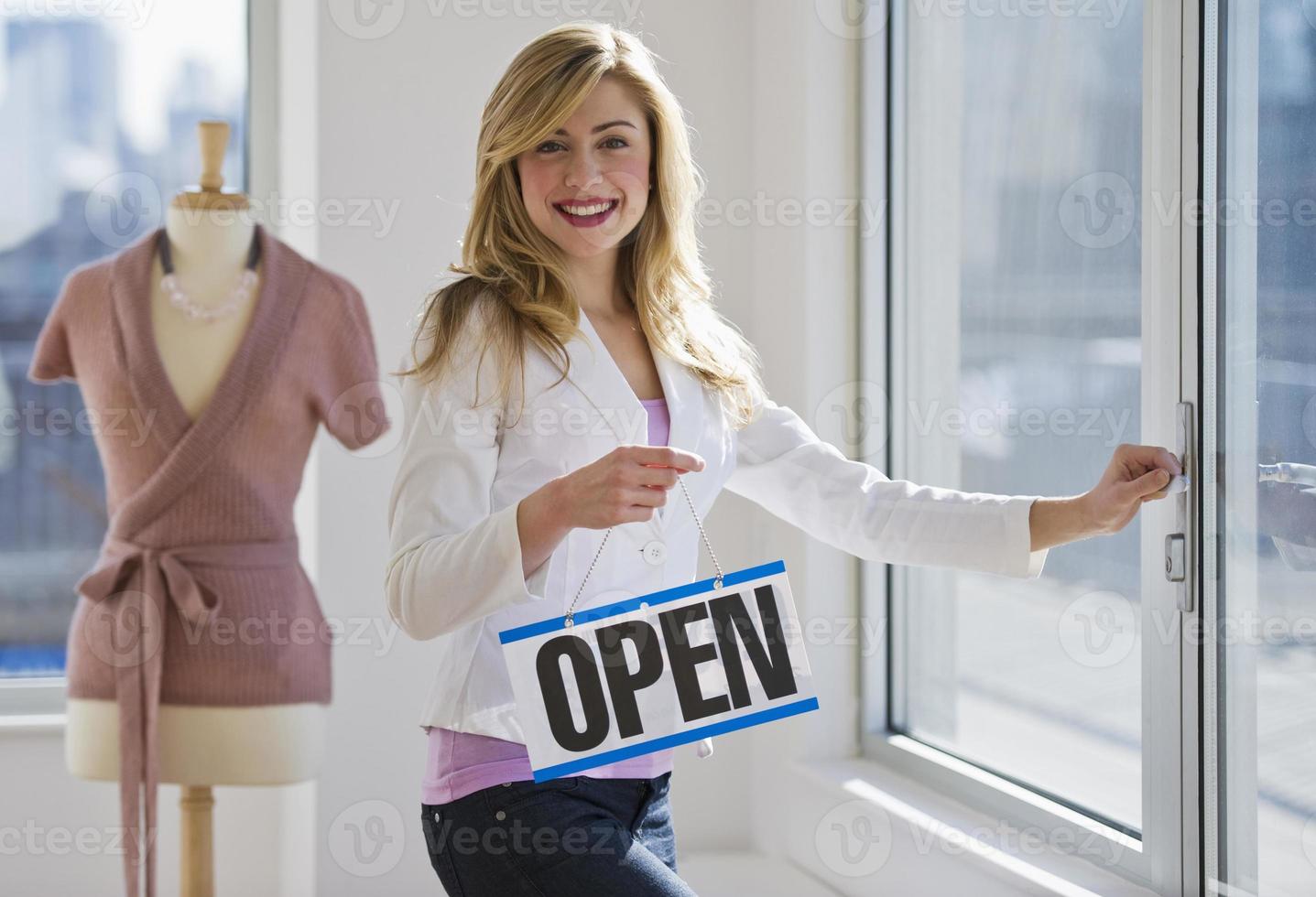 Ladenbesitzer hält offenes Schild foto