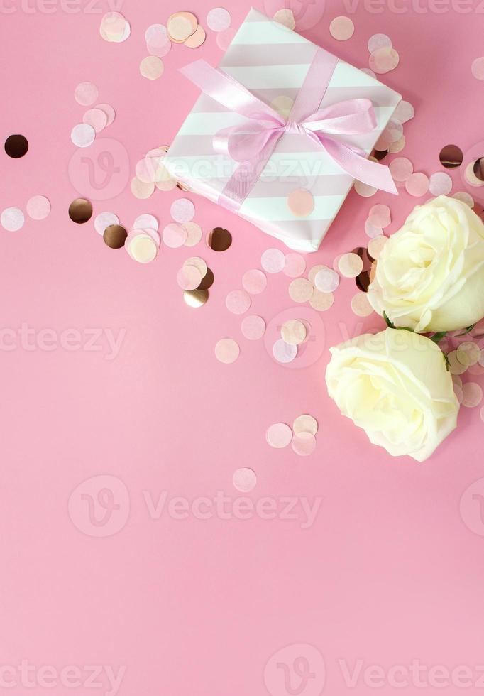 geschenkboxen und rosenblüten auf rosa hintergrund. glücklicher valentinstag, muttertag, geburtstagskonzept. romantische flache Laienkomposition. foto