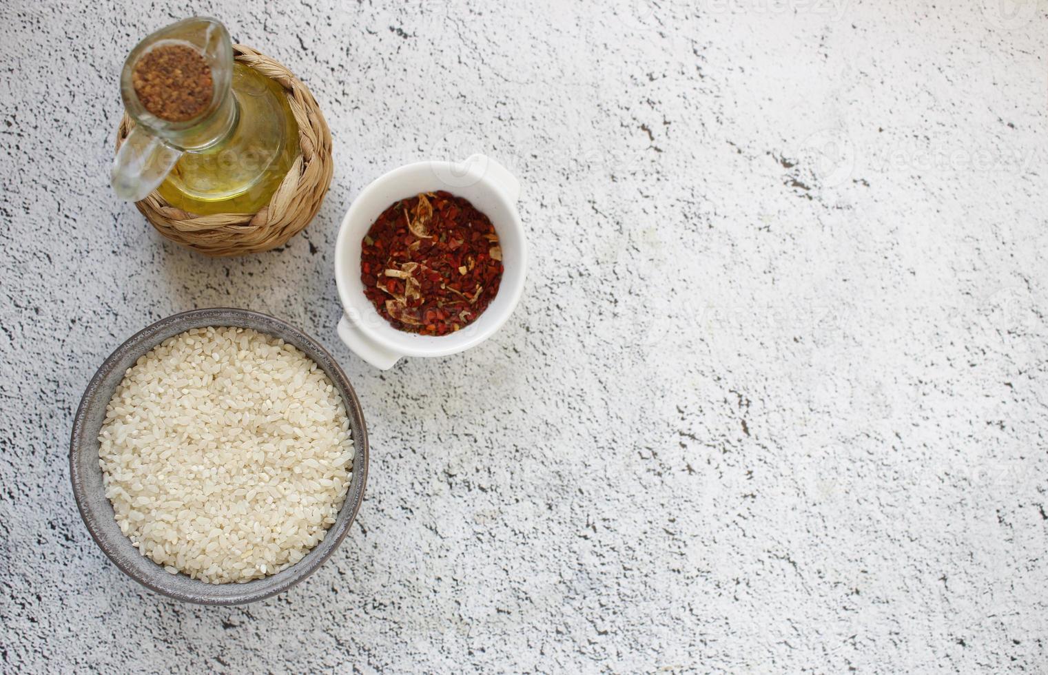 Zutaten für Paella. graue Schüssel mit Reis auf Hintergrund mit Kopierplatz für Ihren Text, Ansicht von oben. natürliches Lebensmittel mit hohem Proteingehalt foto