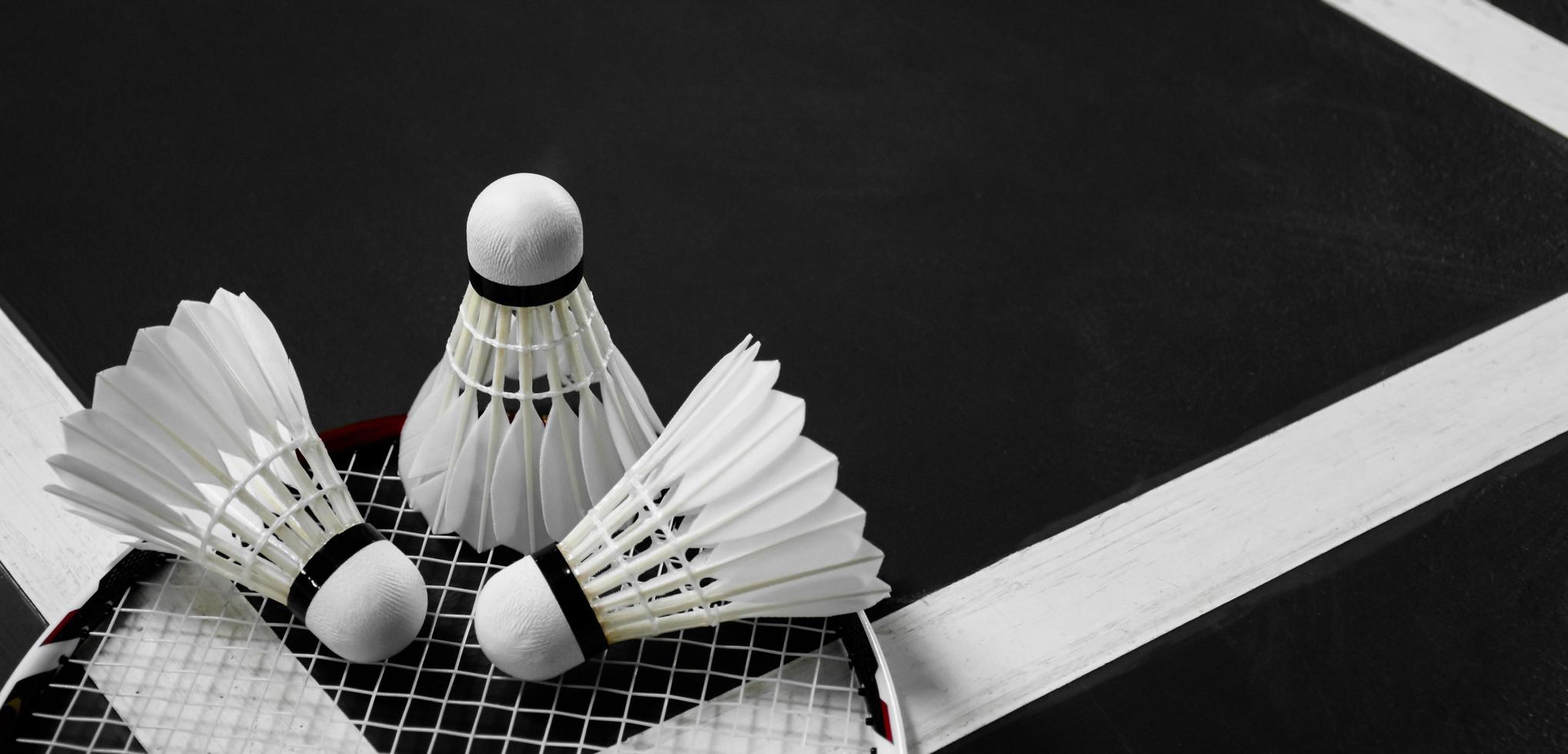 Badminton-Sportgeräte, Federbälle, Schläger, Griff, auf dem Boden des Indoor-Badmintonplatzes. foto