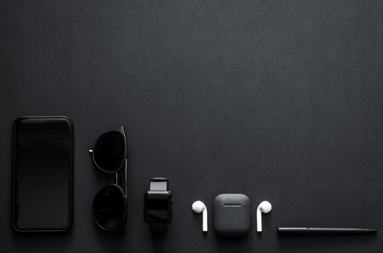 Männer-Gadgets im modernen Lebensstil auf dunklem Hintergrund für minimalistisches, flaches, schwarzes Konzept. foto