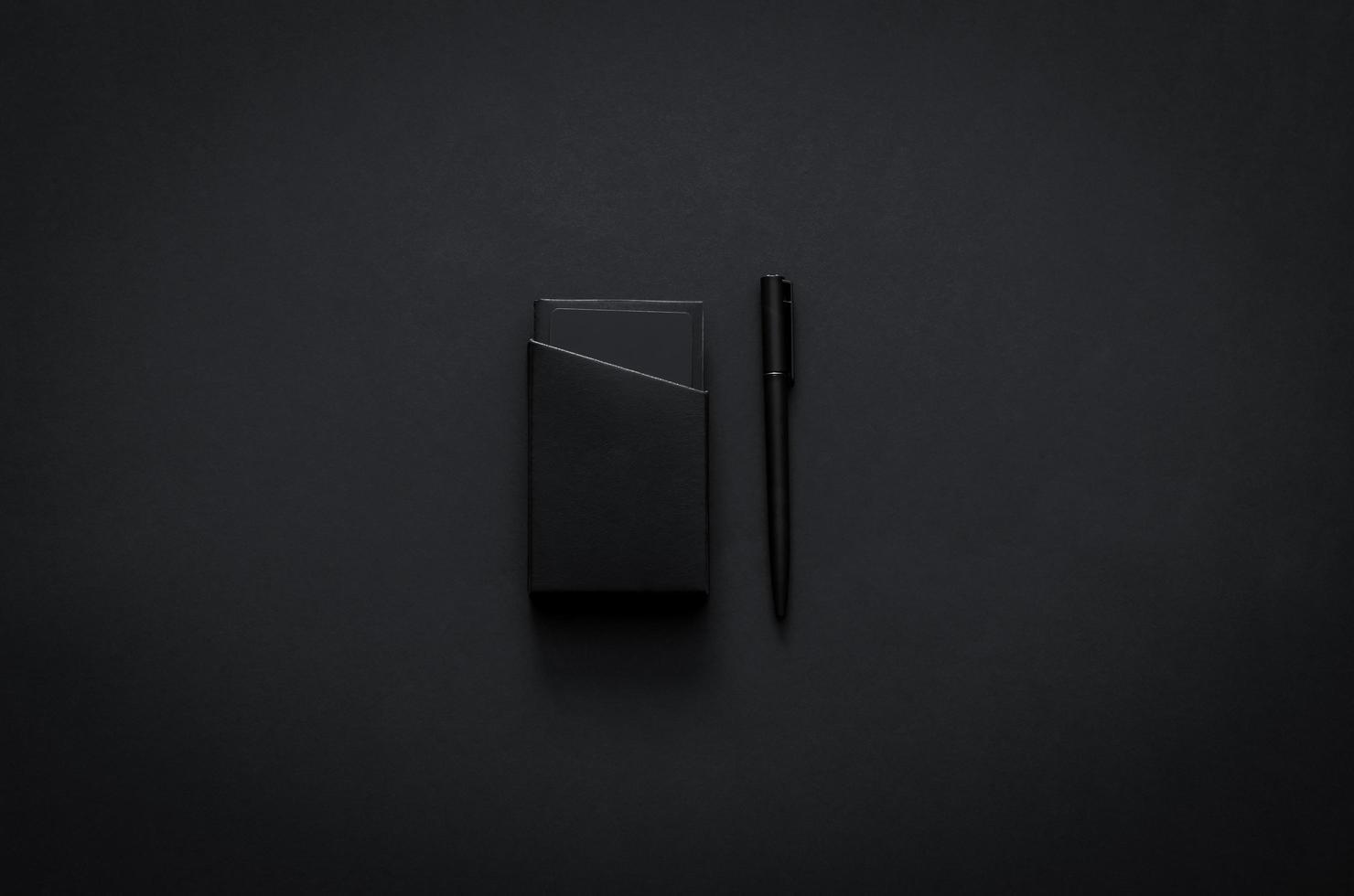 namenskartenbox und stift im modernen lebensstil auf dunklem hintergrund für minimalistisches flaches schwarzes konzept. foto