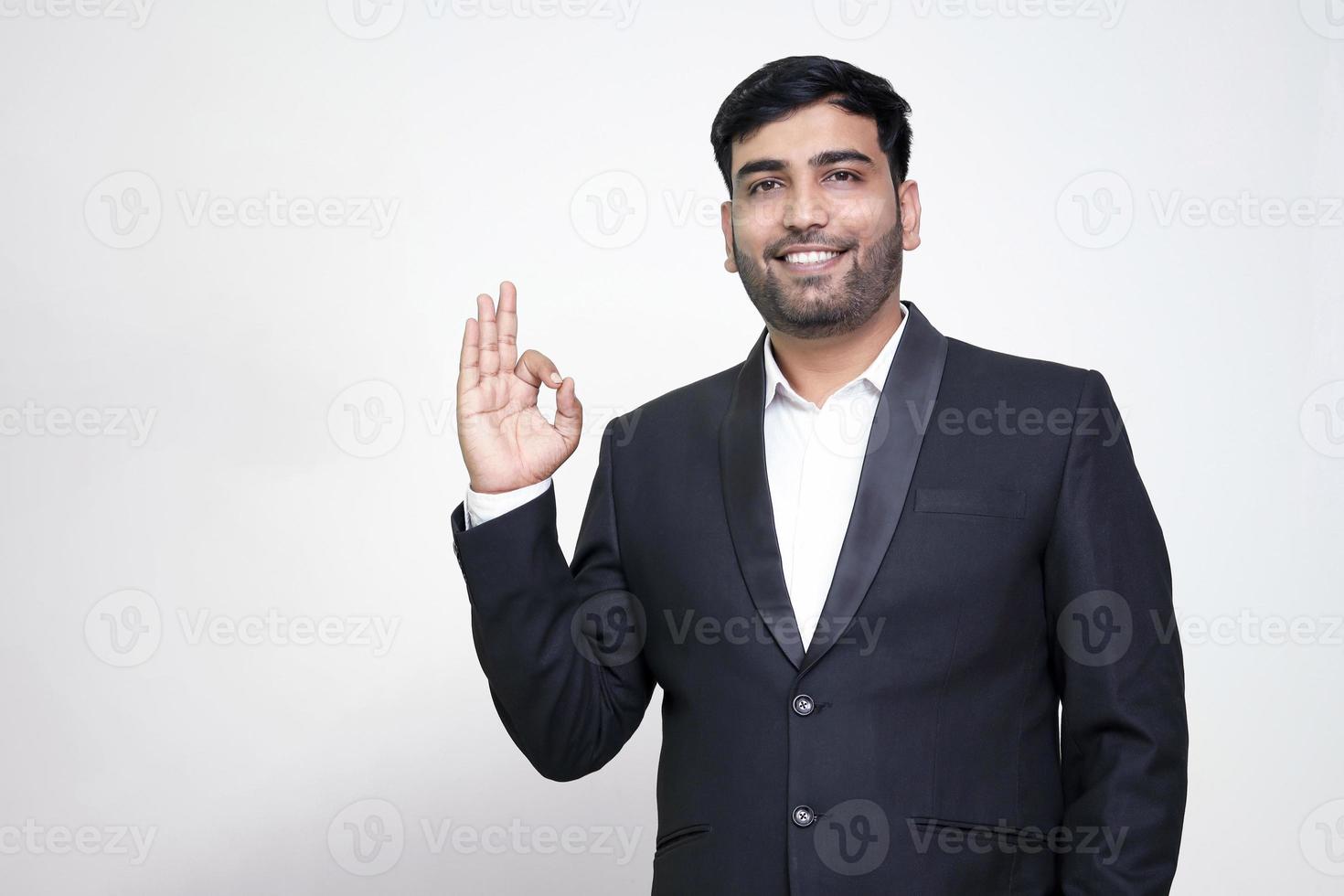 Porträt eines fröhlichen jungen Mannes, der eine okay-Geste zeigt, die auf dem weißen, isolierten Hintergrund isoliert ist. foto