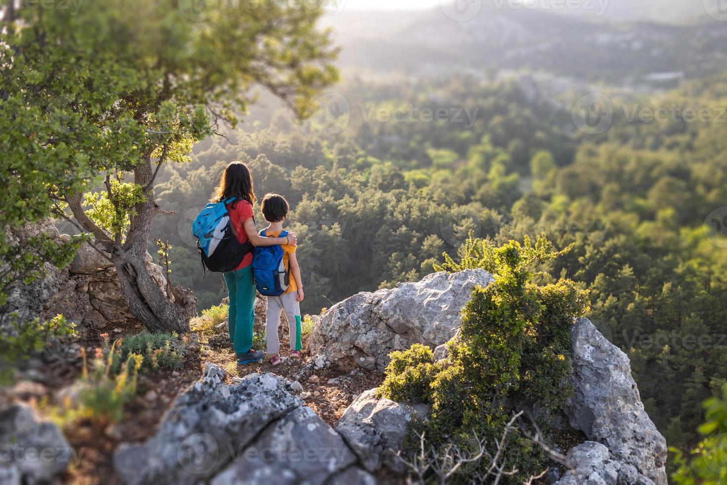 eine frau reist mit kind, junge mit seiner mutter schaut auf die berge foto