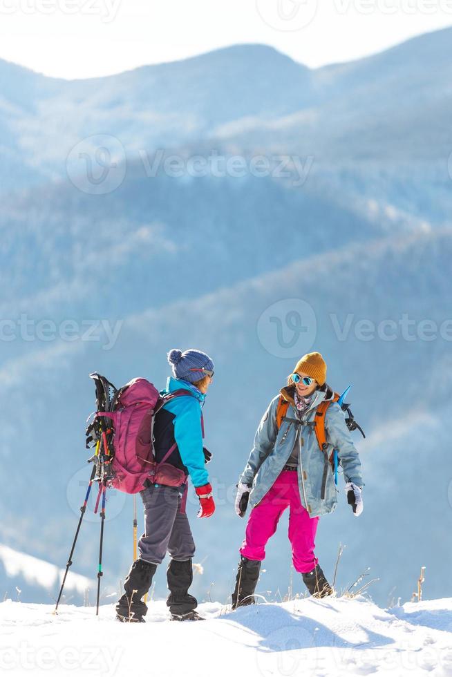 Zwei Frauen kletterten während einer Winterwanderung auf den Gipfel des Berges foto