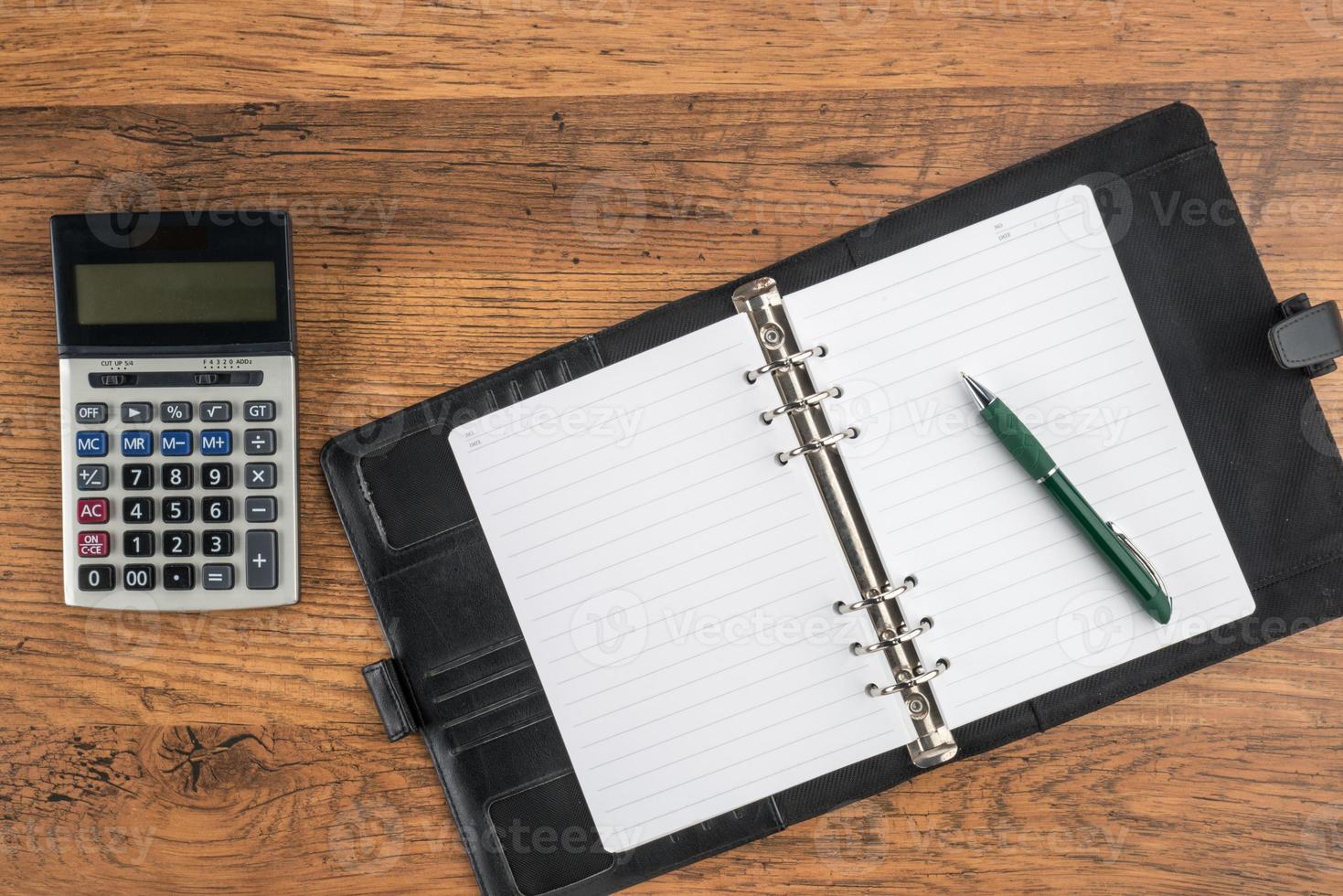 Notizbuch und Stift mit Taschenrechner auf dem Schreibtisch foto