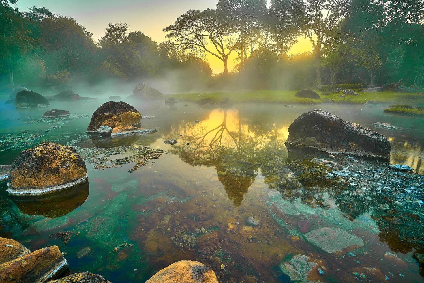 heiße quellen onsen natürliches bad im nationalpark chae son, lampang thailand. morgens sonnenaufgang. natürliches heißes quellenbad umgeben von bergen in nordthailand. weicher fokus. foto