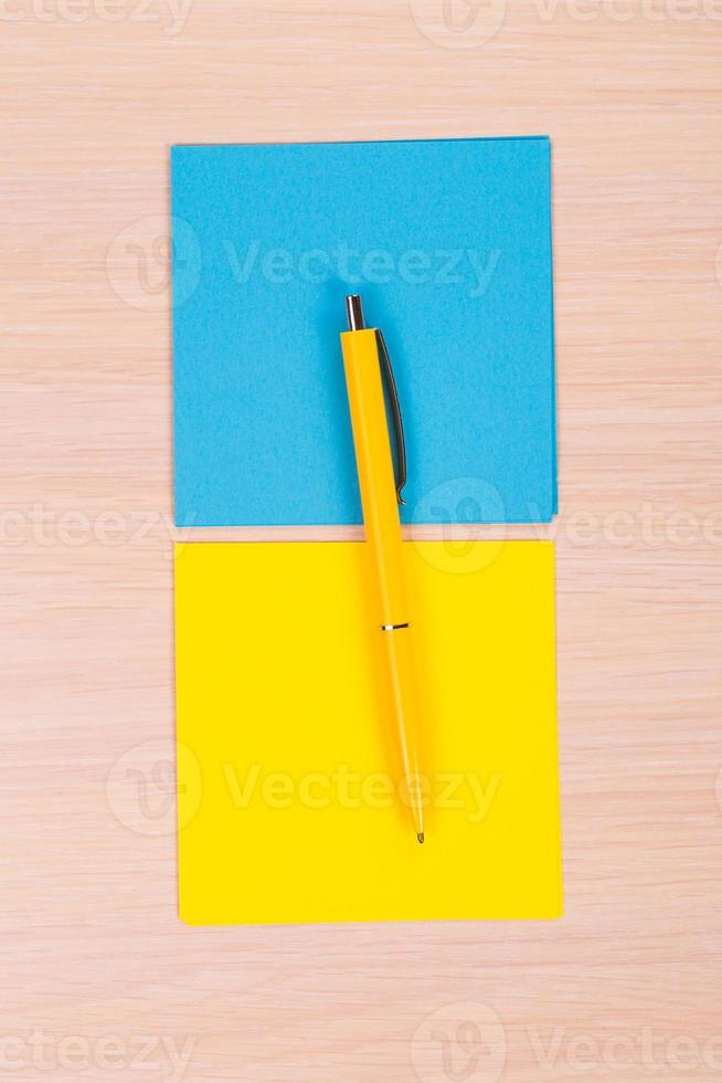 gelbes und blaues Papier mit Stift foto