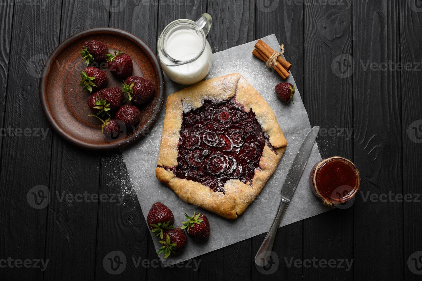 erdbeer-galette auf dunklem holzhintergrund. hausgemacht foto