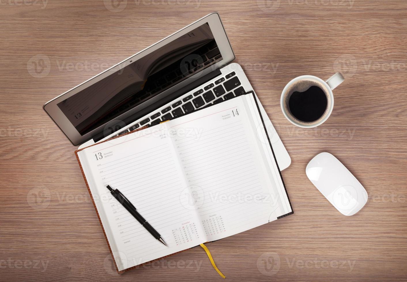 Notizblock, Laptop und Kaffeetasse auf Holztisch foto