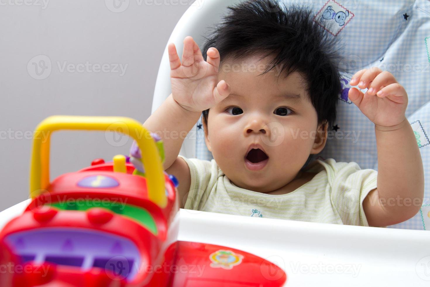kleines asiatisches Baby auf Hochstuhl foto