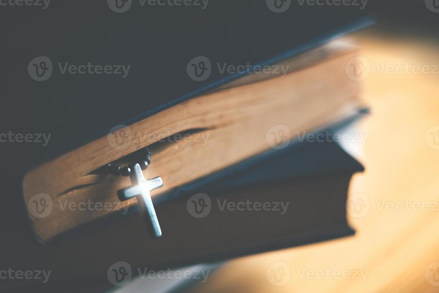 Nahaufnahme der hölzernen christlichen Kreuzkette neben der Heiligen Bibel foto
