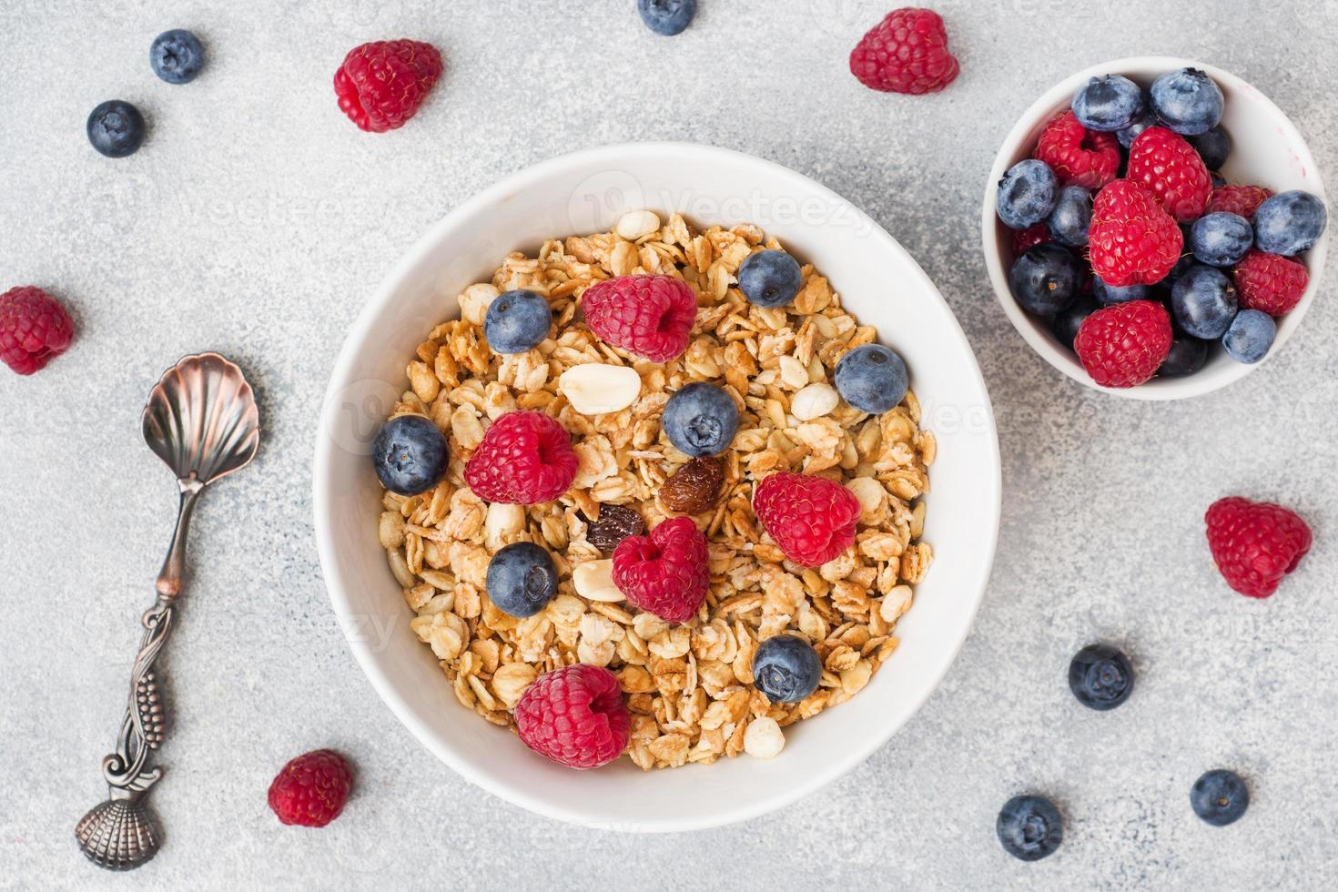 gesundes Frühstück. frisches Müsli, Müsli mit Joghurt und Beeren auf grauem Hintergrund. Platz kopieren foto