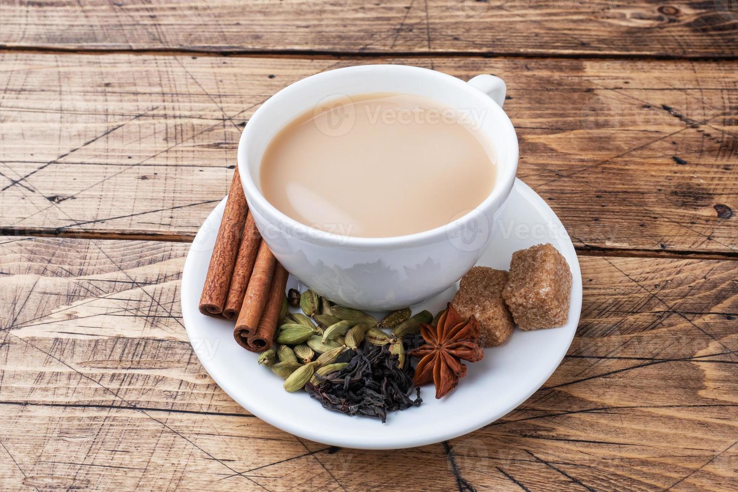 indisches getränk masala tee mit milch und gewürzen. Kardamomstangen Zimt Sternanis Rohrzucker. hölzerner hintergrundkopienraum. foto