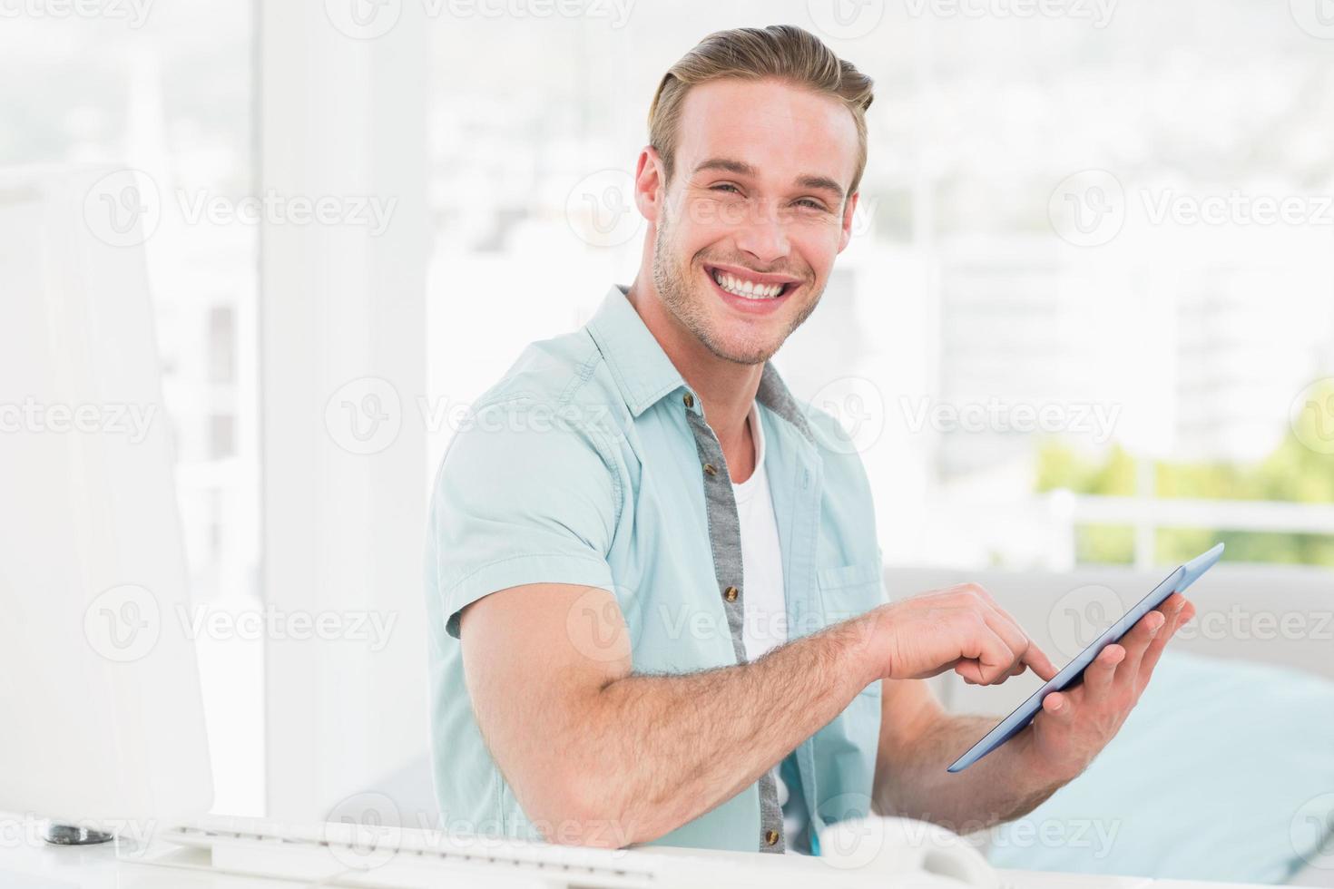 glücklicher lässiger Geschäftsmann mit Tablette foto