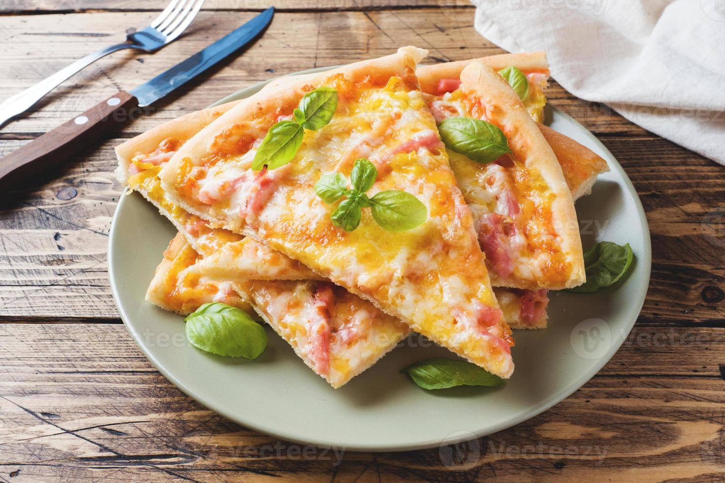 Stücke hausgemachter Pizza auf einem Teller auf einem Holztisch. foto