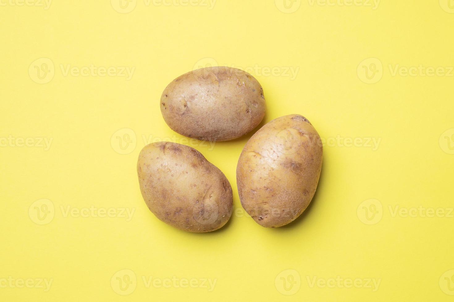 rohe Kartoffelknollen auf gelbem Hintergrund. foto