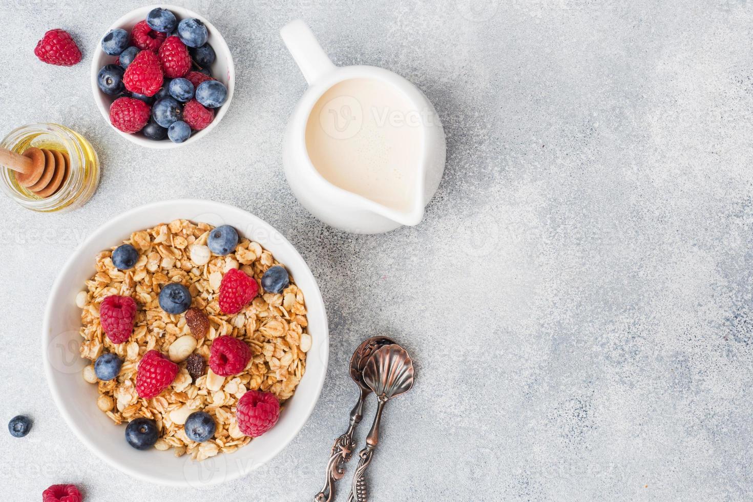 gesundes Frühstück. frisches Müsli, Müsli mit Joghurt und Beeren auf grauem Hintergrund. Platz kopieren foto