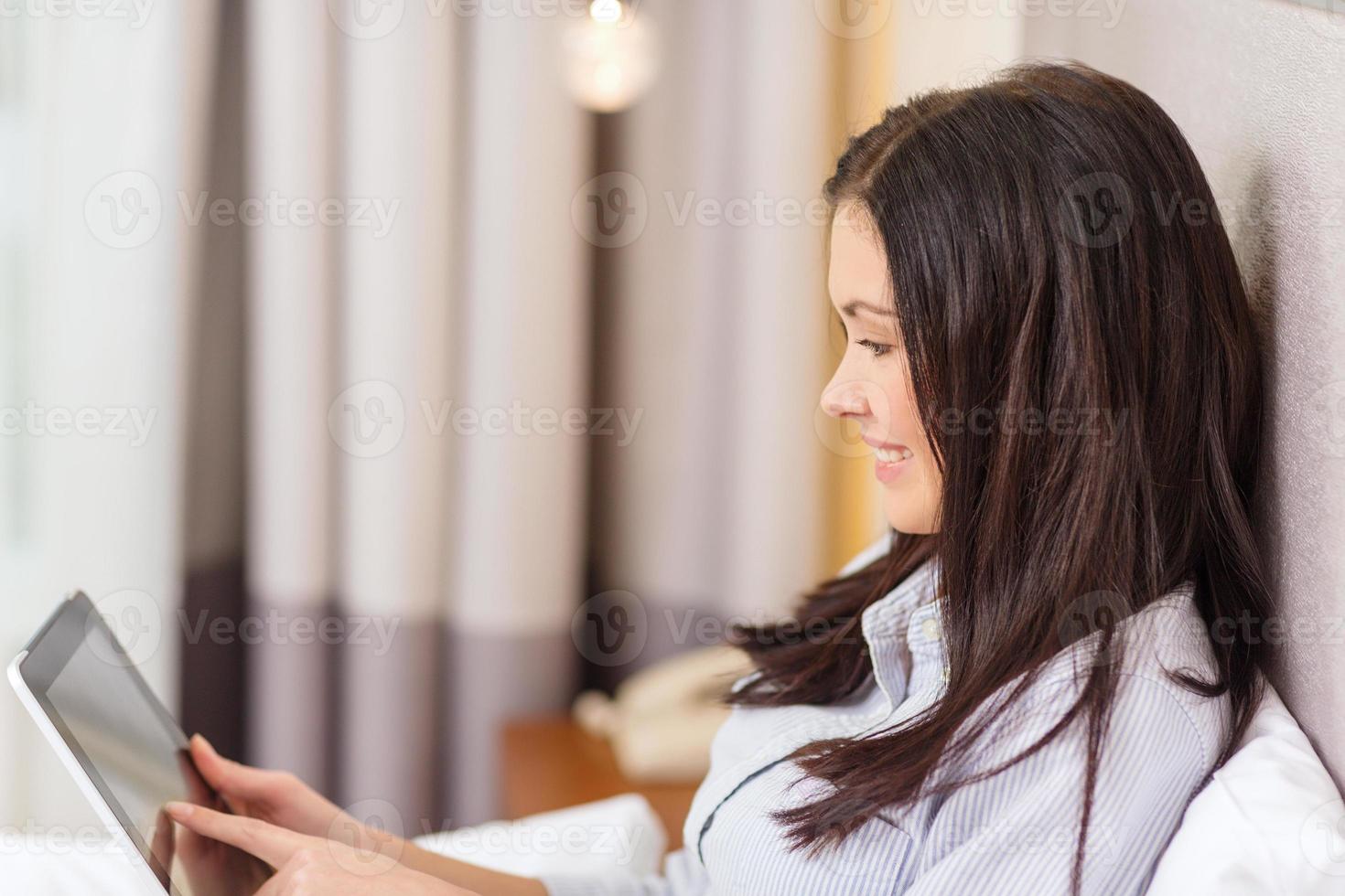 glückliche Geschäftsfrau mit Tablet-PC im Hotelzimmer foto