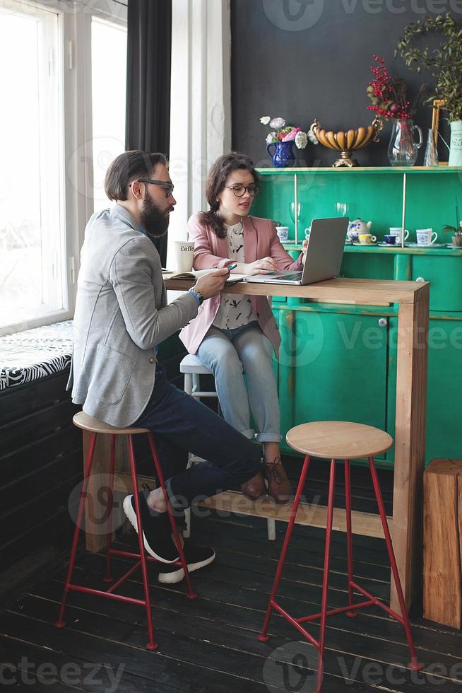 modernes Team arbeitet im Café mit Laptop, Smartphone mit Kaffee foto