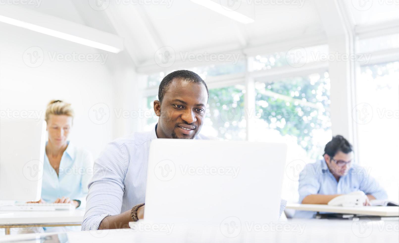 ein afrikanischer Geschäftsmann, der mit seinem Laptop arbeitet foto