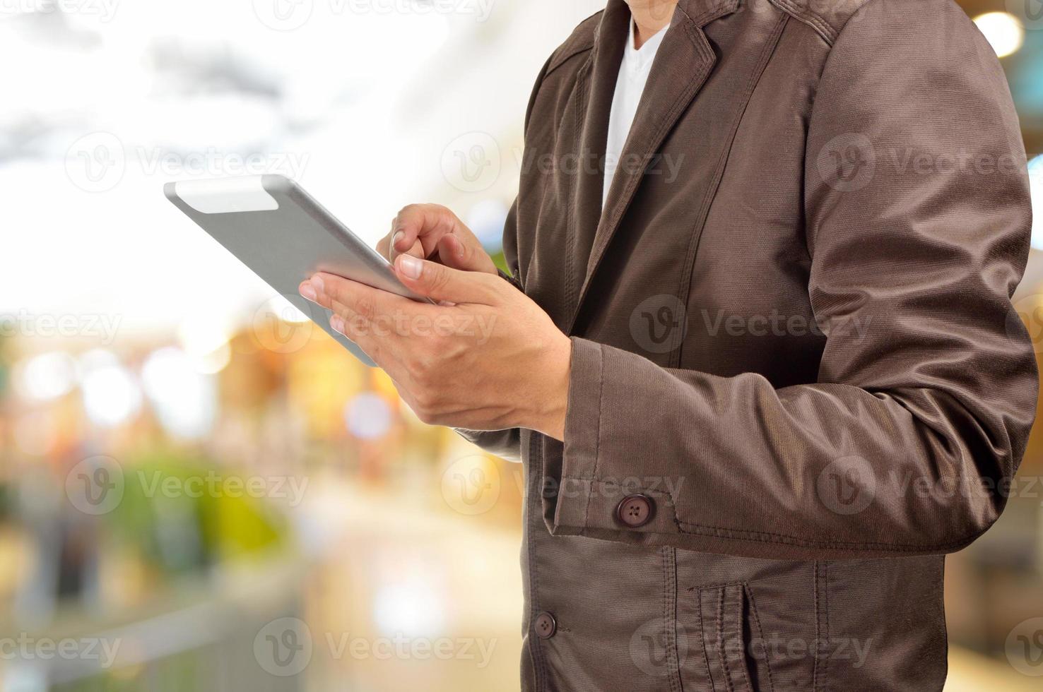 junger Mann Hände, die Tablette im Einkaufszentrum halten foto