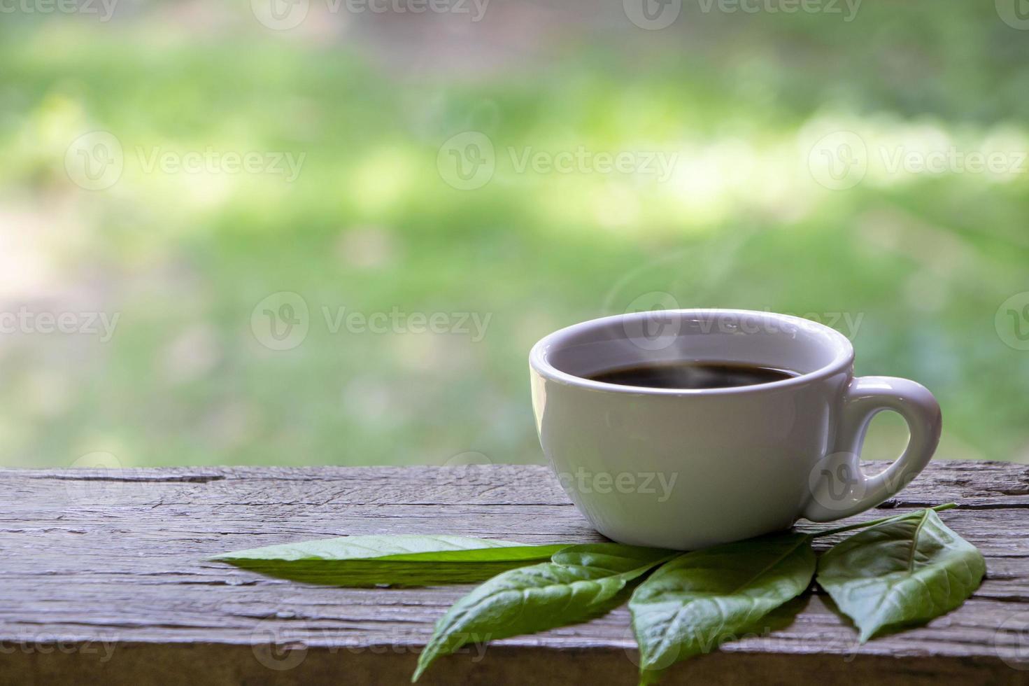 weiße Tasse Kaffee auf einem Holztisch foto