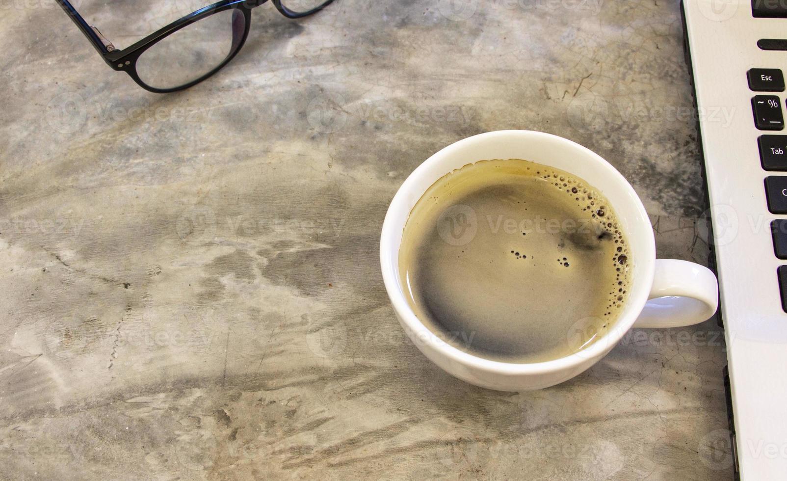 Keramische weiße Tasse Kaffee auf einem rustikalen Betontisch. foto