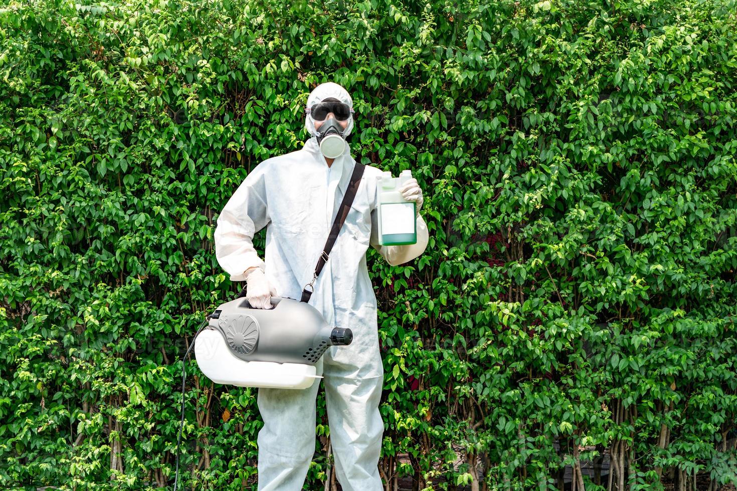 Professioneller Techniker im Präventionsanzug und schwarze Brille mit seiner Sterilisationsmaschine und Desinfektionswasser in der Hand. er ist bereit, das reinigende coronavirus covid19 herauszunehmen. foto