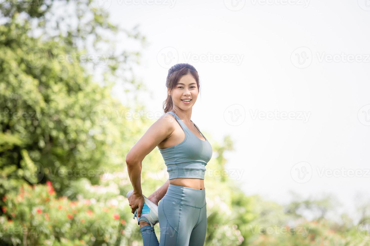 Sportlerin wärmt sich im Freien auf, Fitness-Frau in Sportkleidung wärmt Training auf und macht Dehnungsübungen im Freien foto