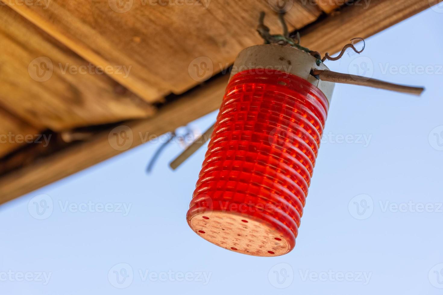 rotes zylindrisches Licht, das von einer Decke hängt foto