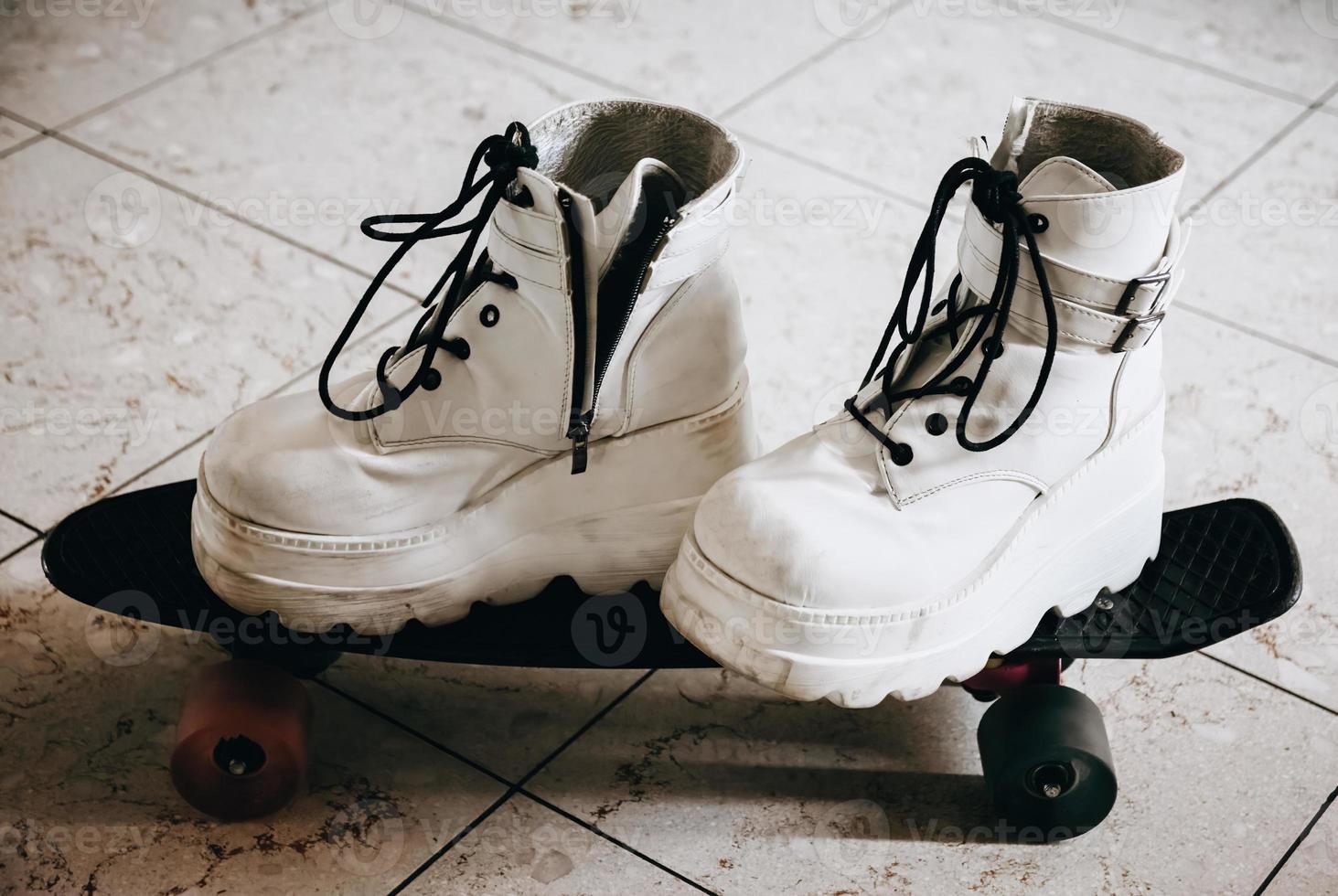 weiße Schuhe auf einem Skateboard foto