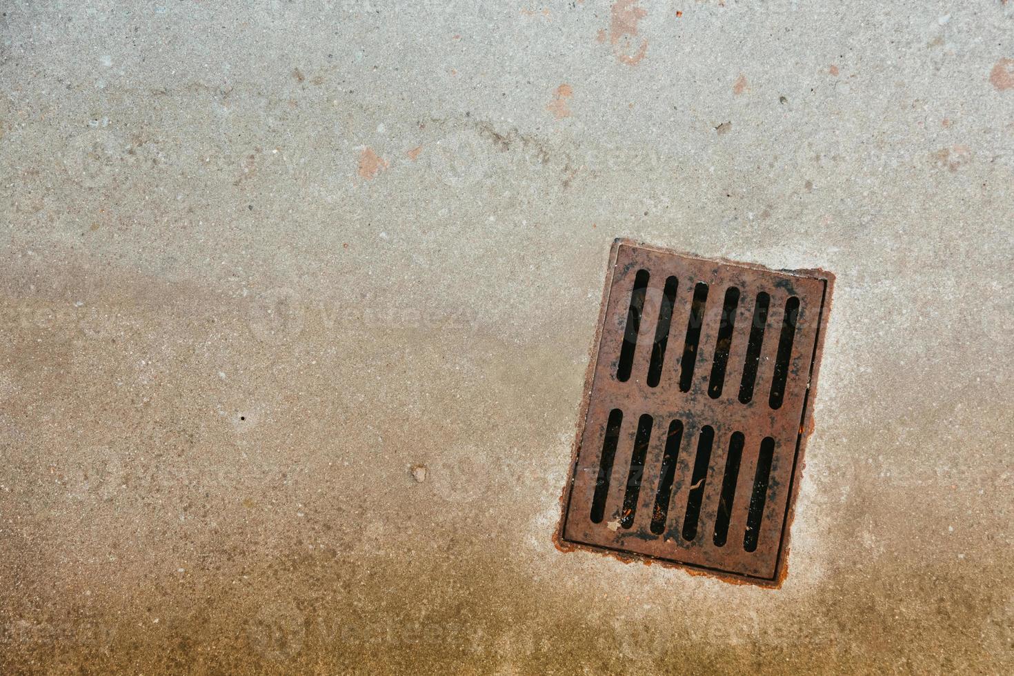 Altes rostiges Metallentwässerungsgitter in Beton foto