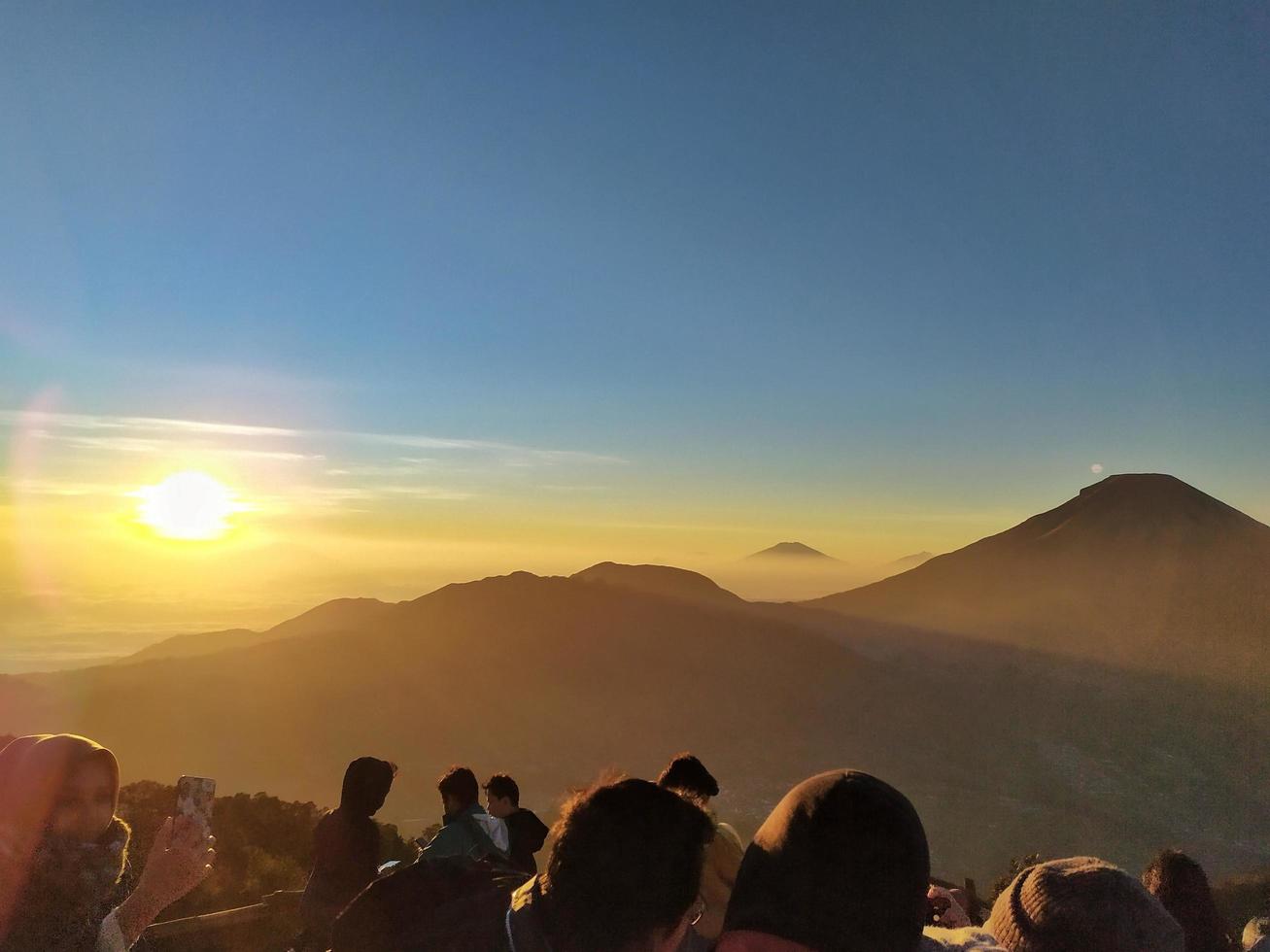 wonosobo, indonesien 31. august 2019. prau berg, die schöne silhouette des sonnenaufgangs und der blick auf den berg, menschen am morgen foto