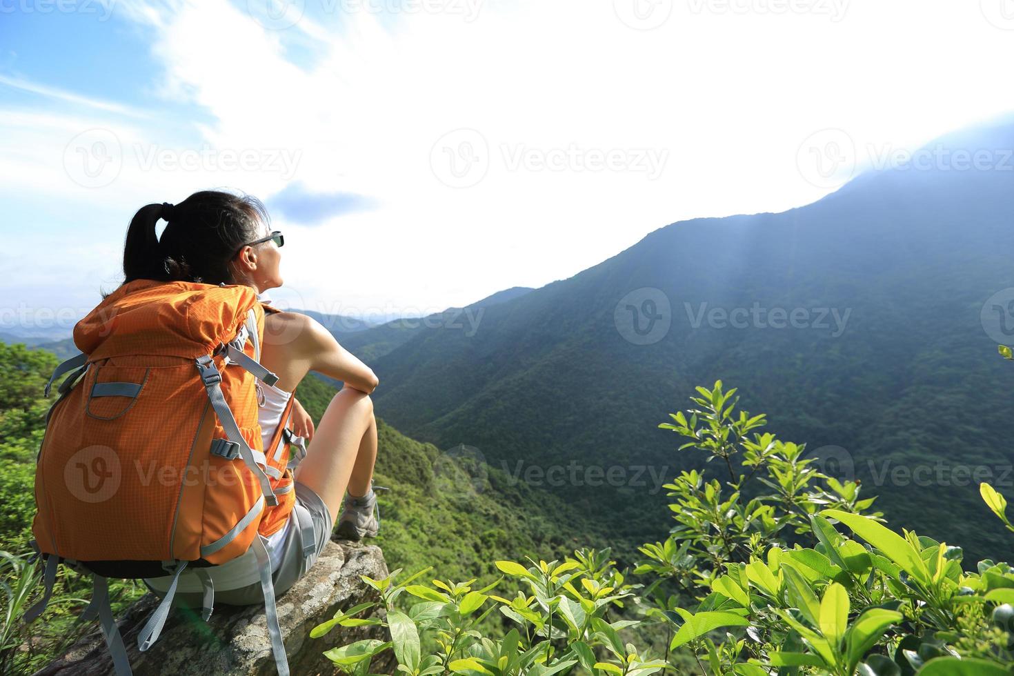 Frau Backpacker genießen Sie die Aussicht auf Berggipfel Klippe foto