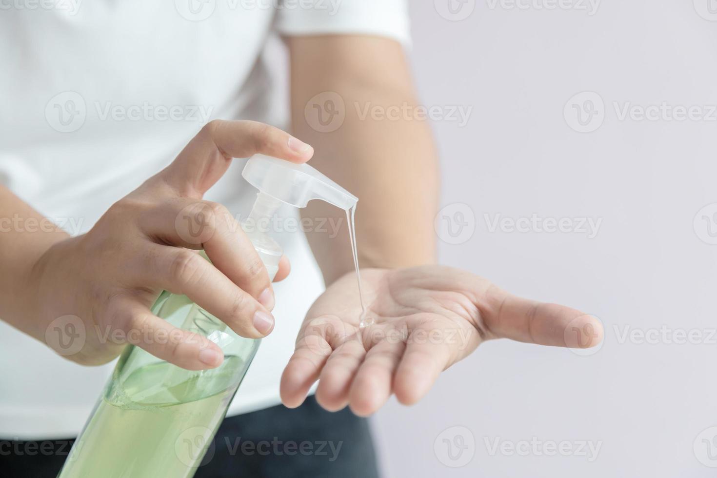 Die Frau drückte das Alkoholgel in eine Pumpflasche foto