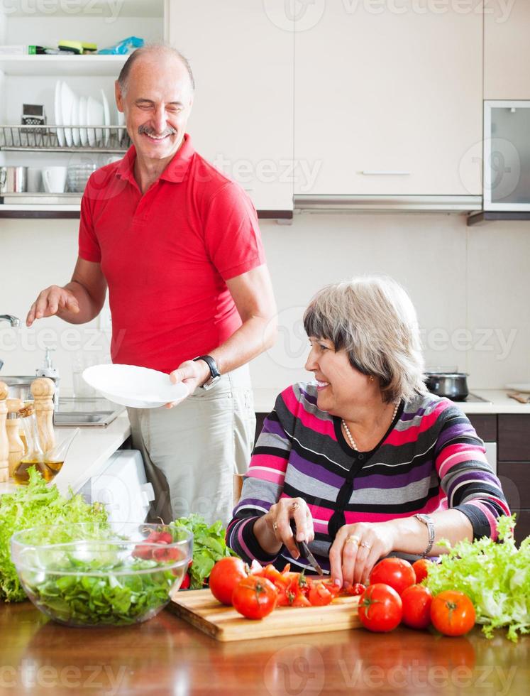 glücklicher älterer Mann und reife Frau, die Hausarbeit tun foto