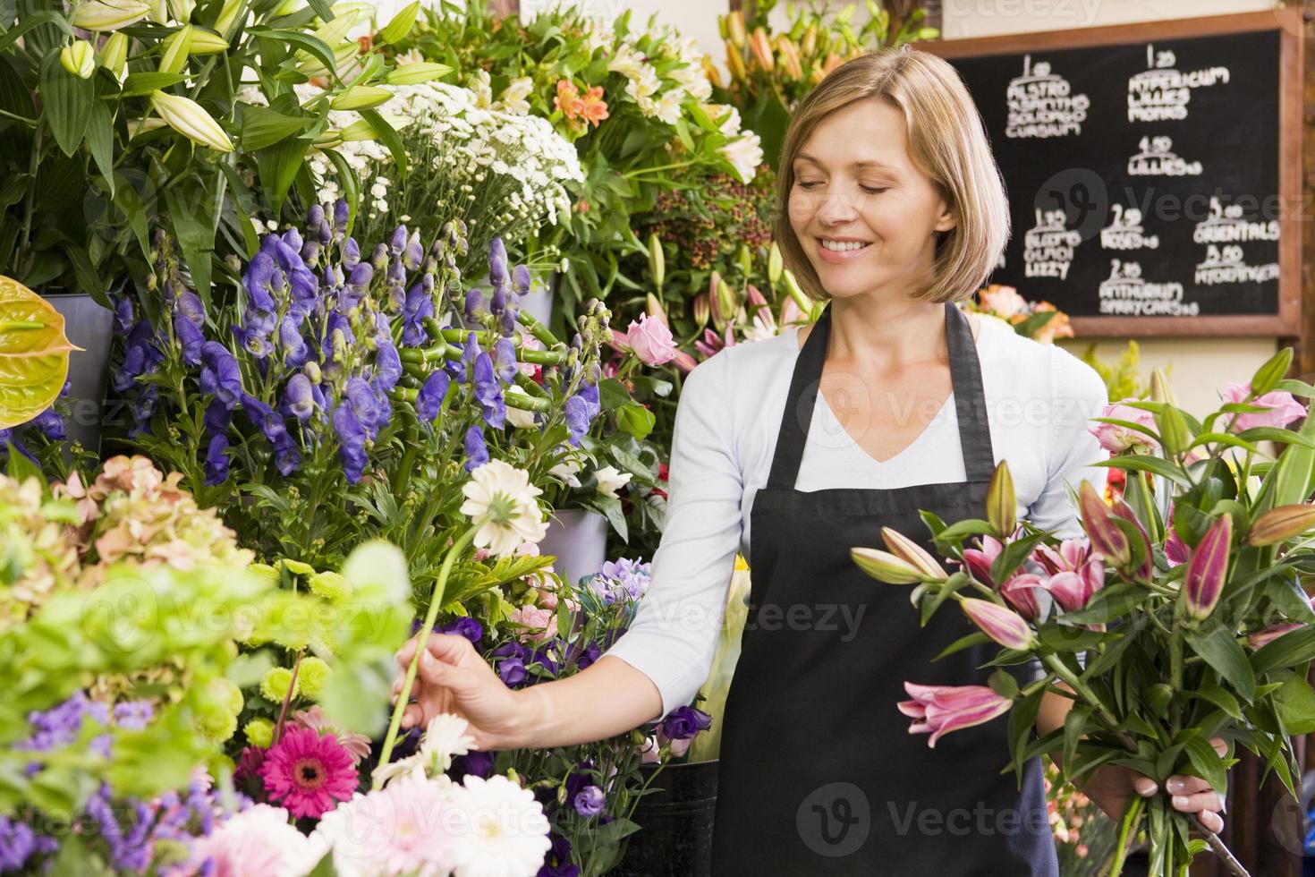 Frau arbeitet am Blumenladen lächelnd foto
