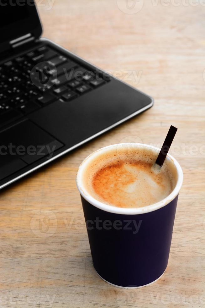 heiße Latte Kaffee Pappbecher mit Computer Notebook foto