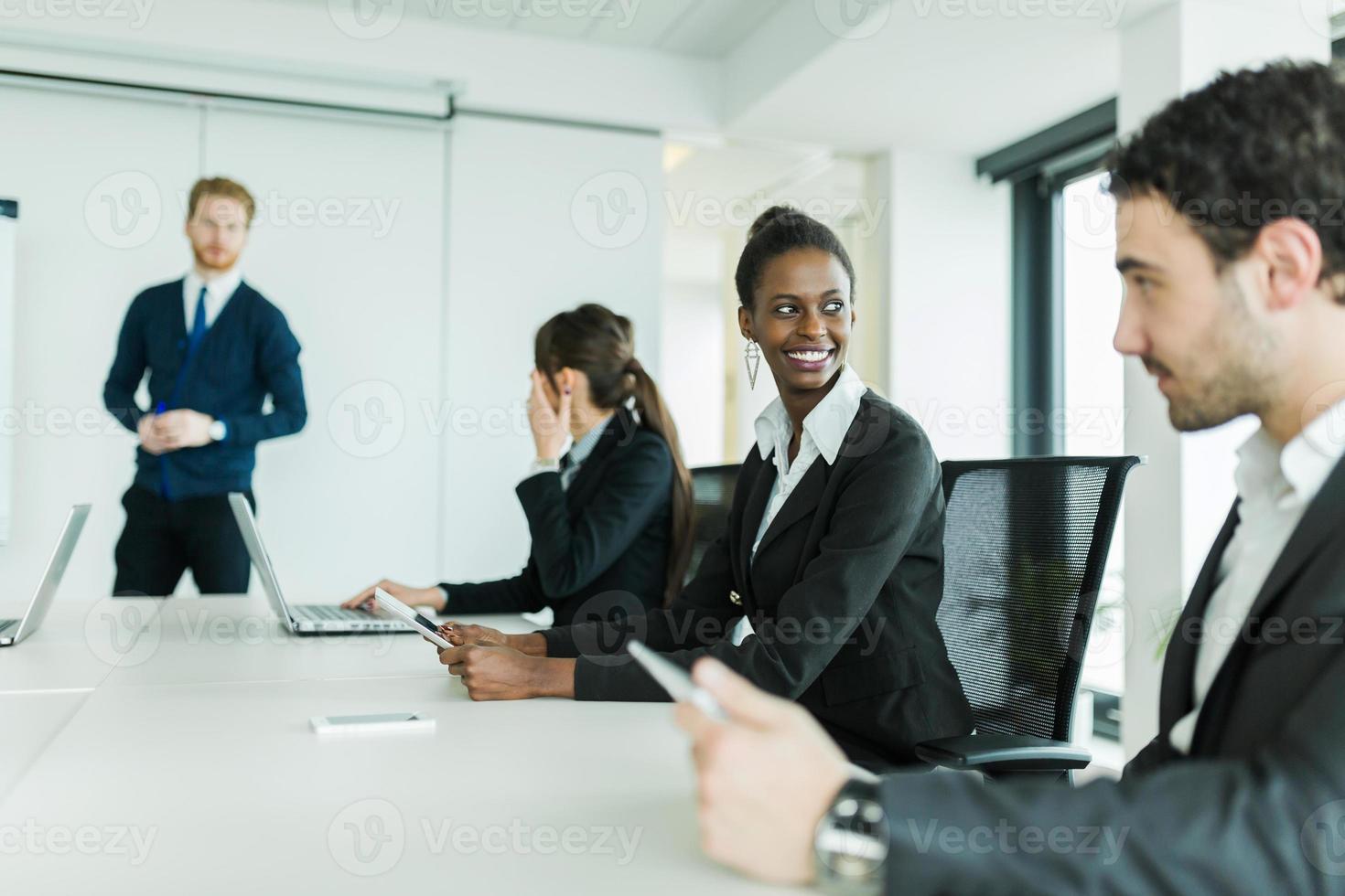 junge Geschäftsleute, die an einem Konferenztisch sitzen foto