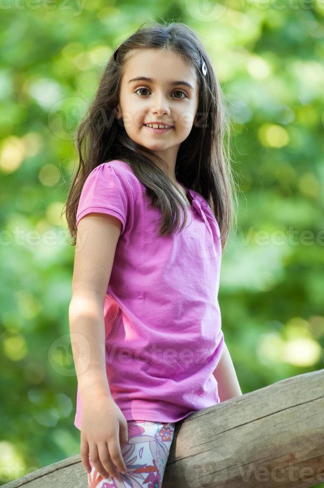 süßes kleines Mädchen auf einer Holzstange foto