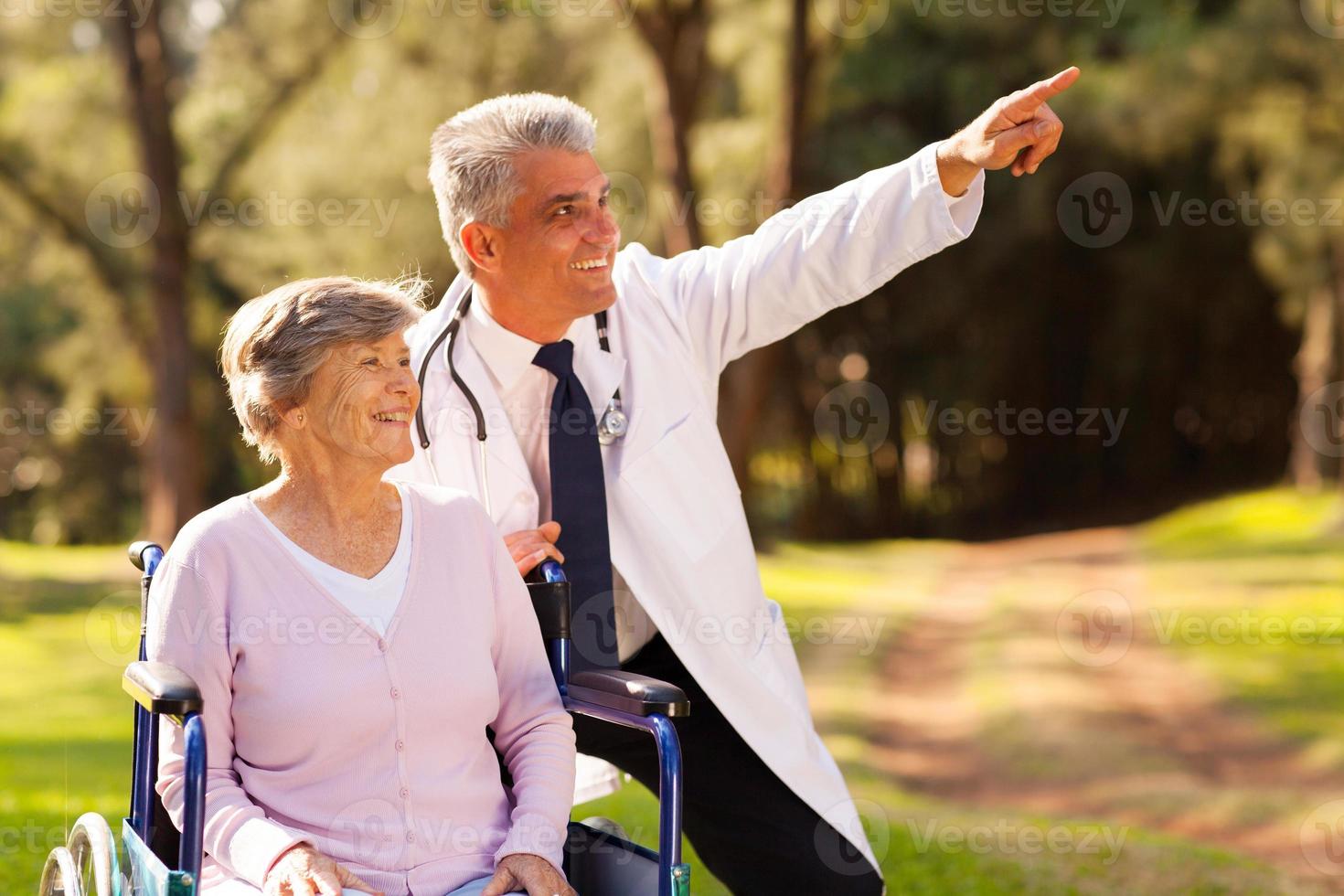freundlicher Arzt und älterer Patient im Freien für einen Spaziergang foto