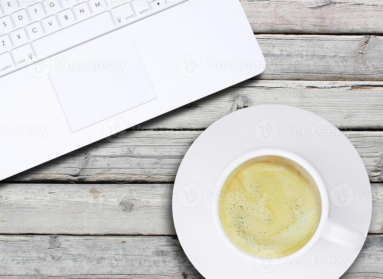 Laptop und eine Tasse Kaffee mit Crema foto