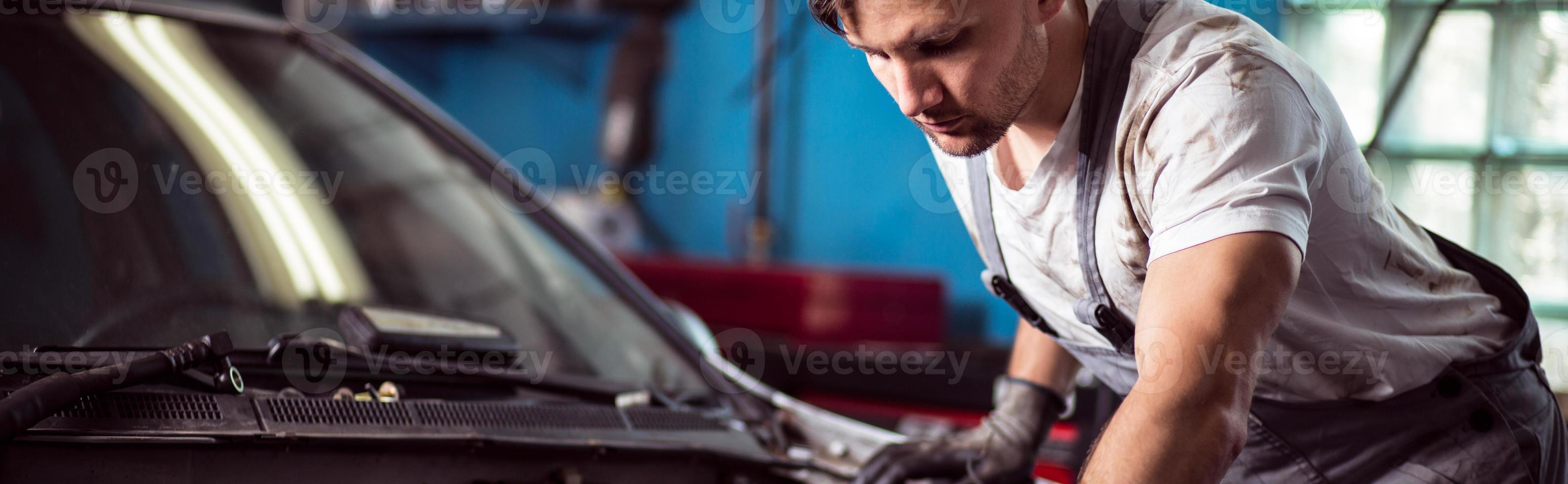 Automechaniker, der das Auto repariert foto