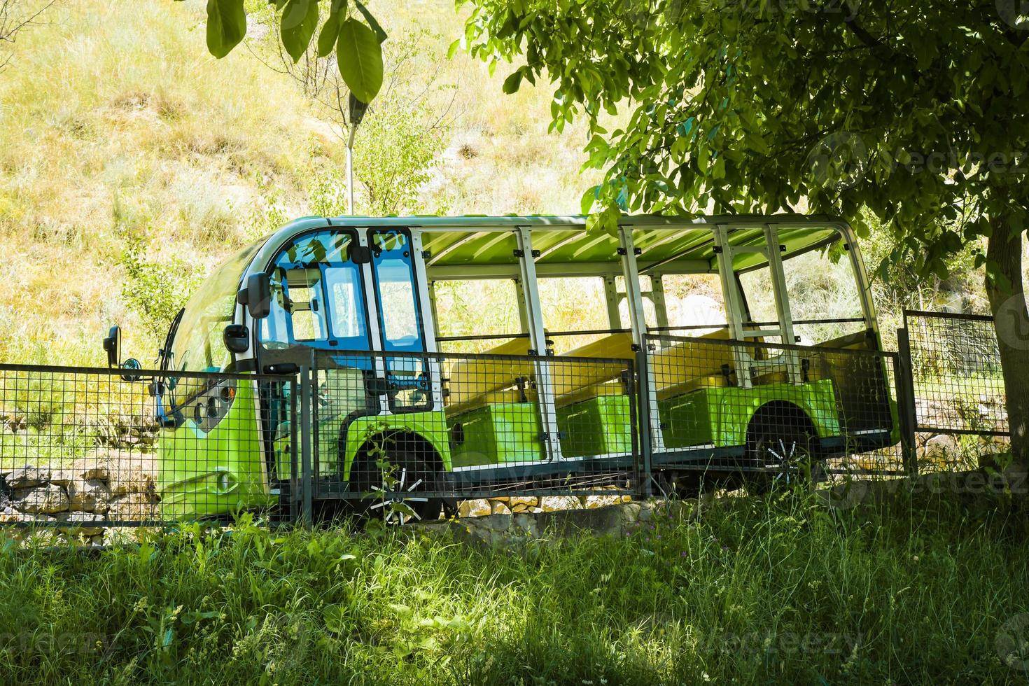 vardzia, georgia, 2022- grüner mini-mus steht bergab mit touristen zur abholung für den transfer zur vardzia-höhlenstadt - berühmte touristenattraktion foto